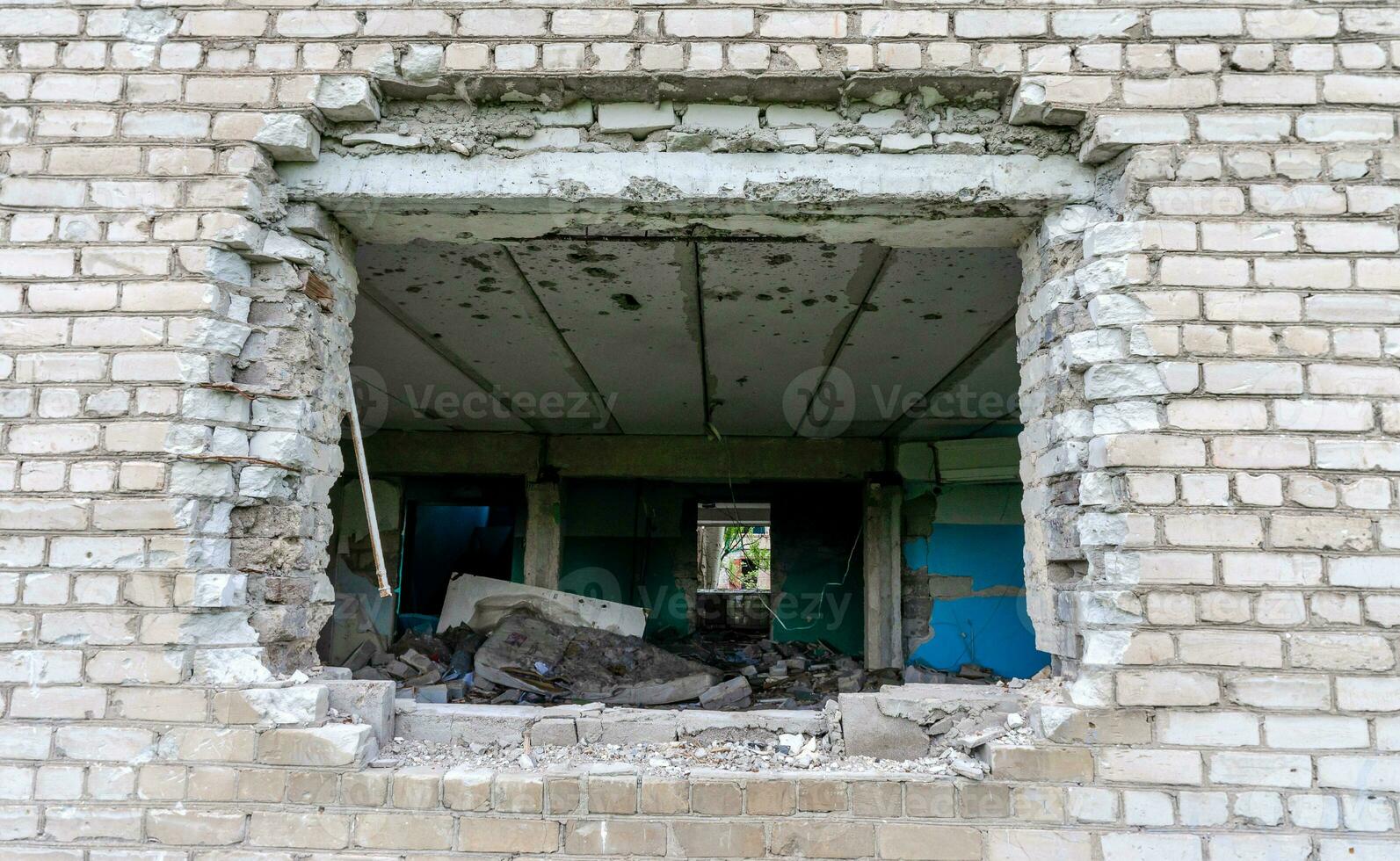 bomb hole in the wall destroyed school building in Ukraine photo