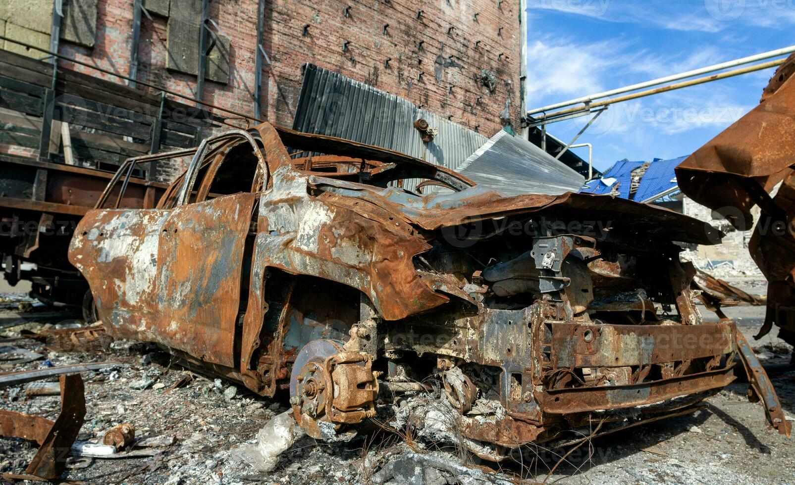 burnt car on the street of the ruined city photo