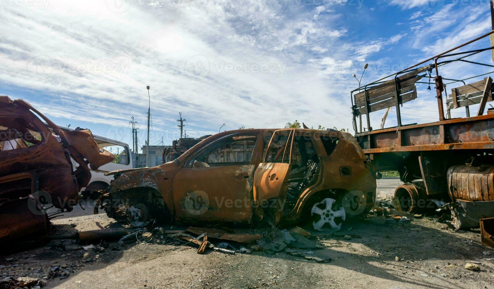 burnt car on the street of the ruined city photo