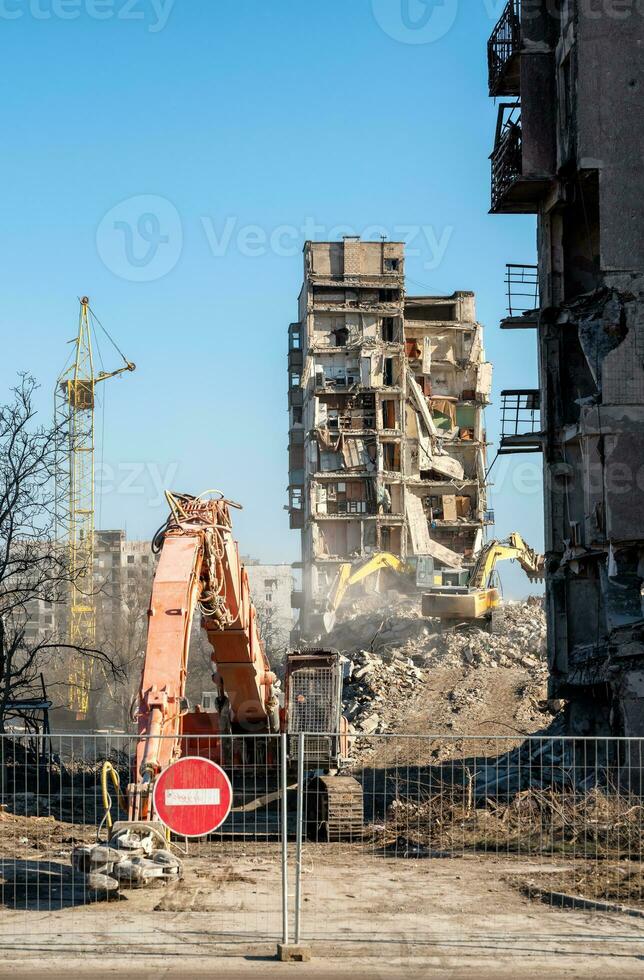 construction equipment destroys houses damaged during the war in Ukraine photo