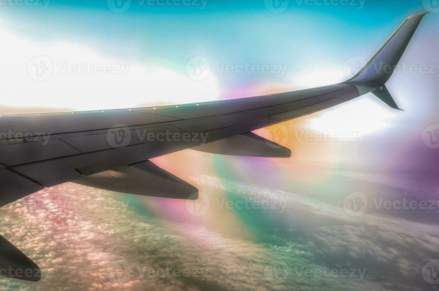 airplane wing in flight above clouds with optical effect photo