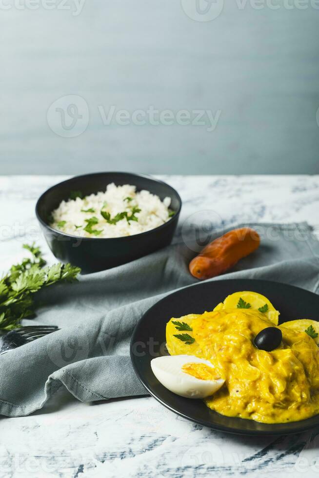 Typical Peruvian dish called Aji de gallina with a portion of rice on a light background. photo