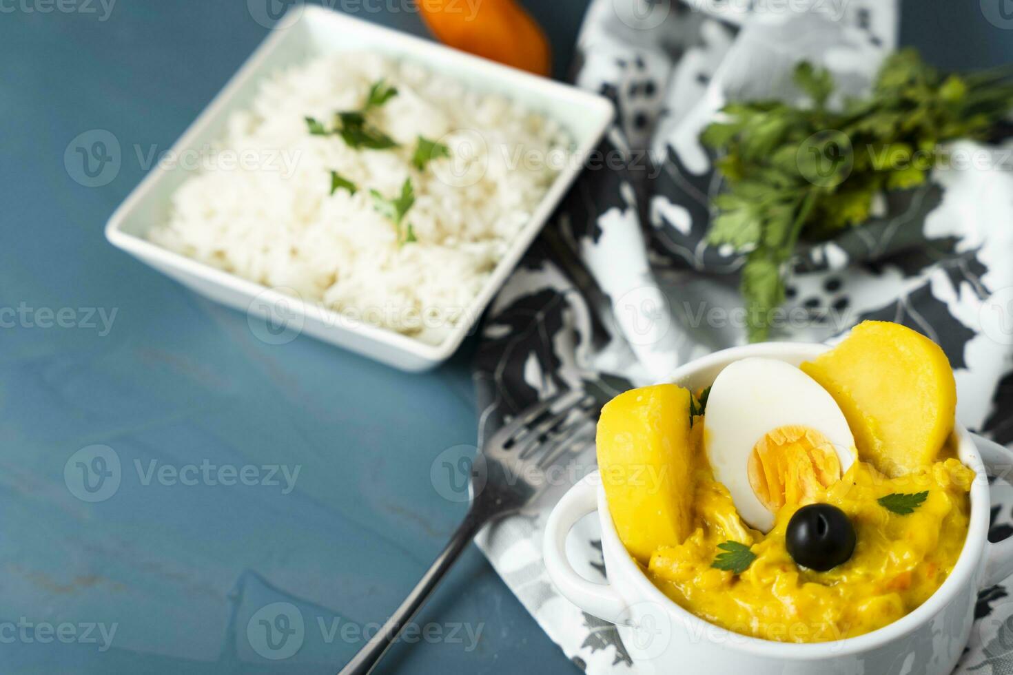 Typical Peruvian dish called Aji de gallina with a portion of rice on a blue background. photo