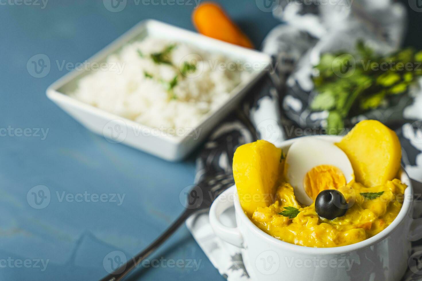 Typical Peruvian dish called Aji de gallina with a portion of rice on a blue background. photo