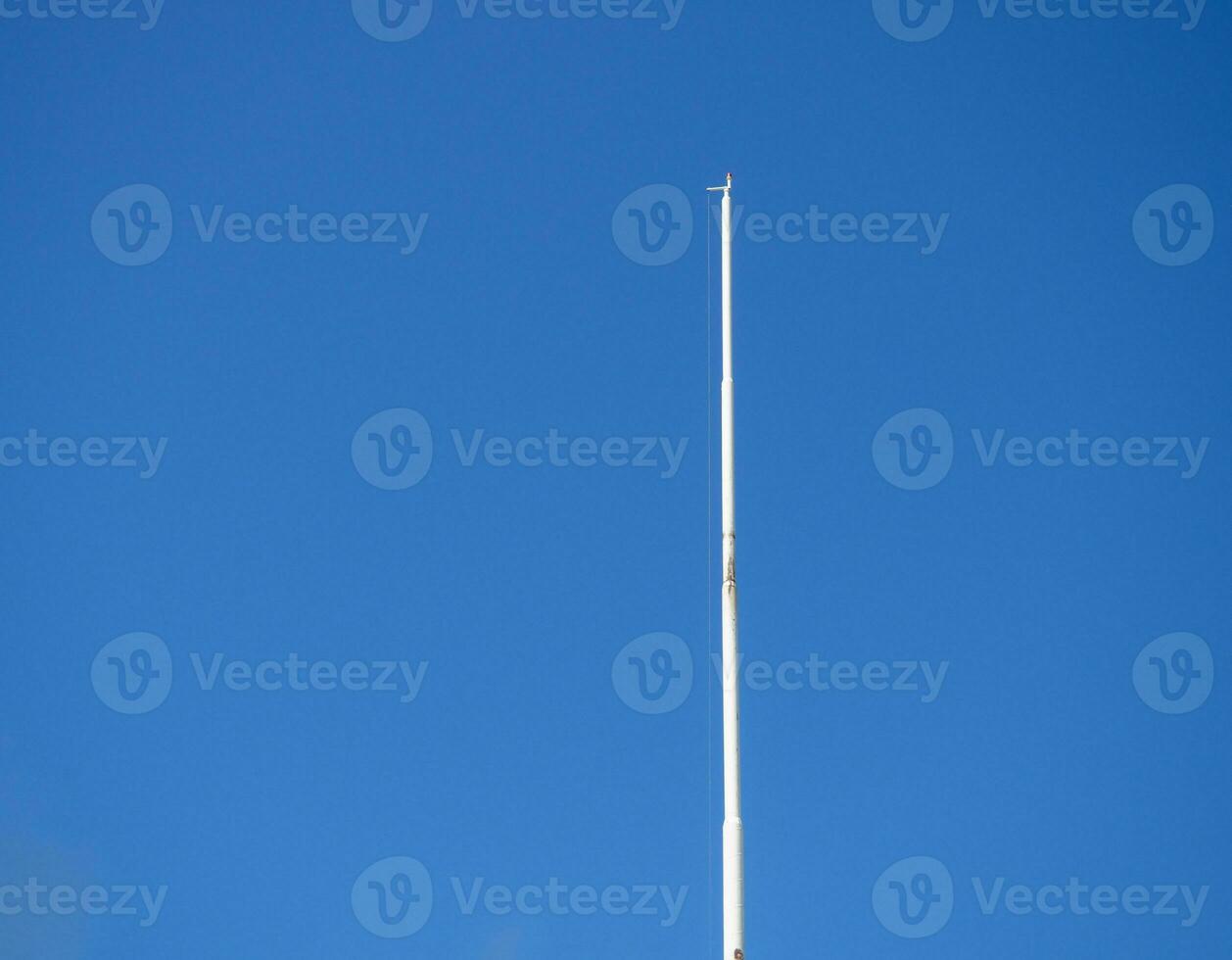 vacío blanco asta de bandera en contra el azul cielo. bajado bandera. foto