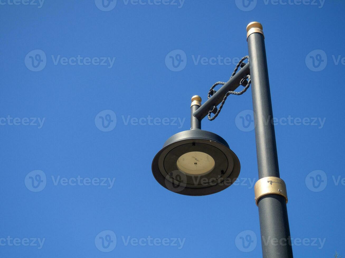 Black lantern against the blue sky. Interesting lamp design. Street lighting. photo