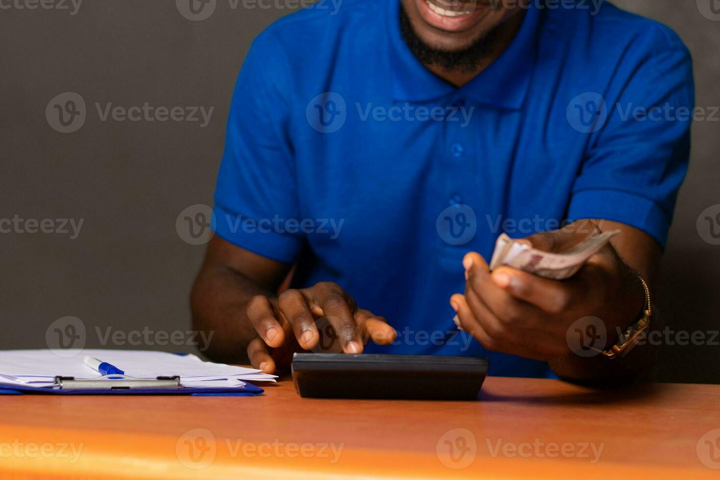 young african man holding some money and doing some calculations photo