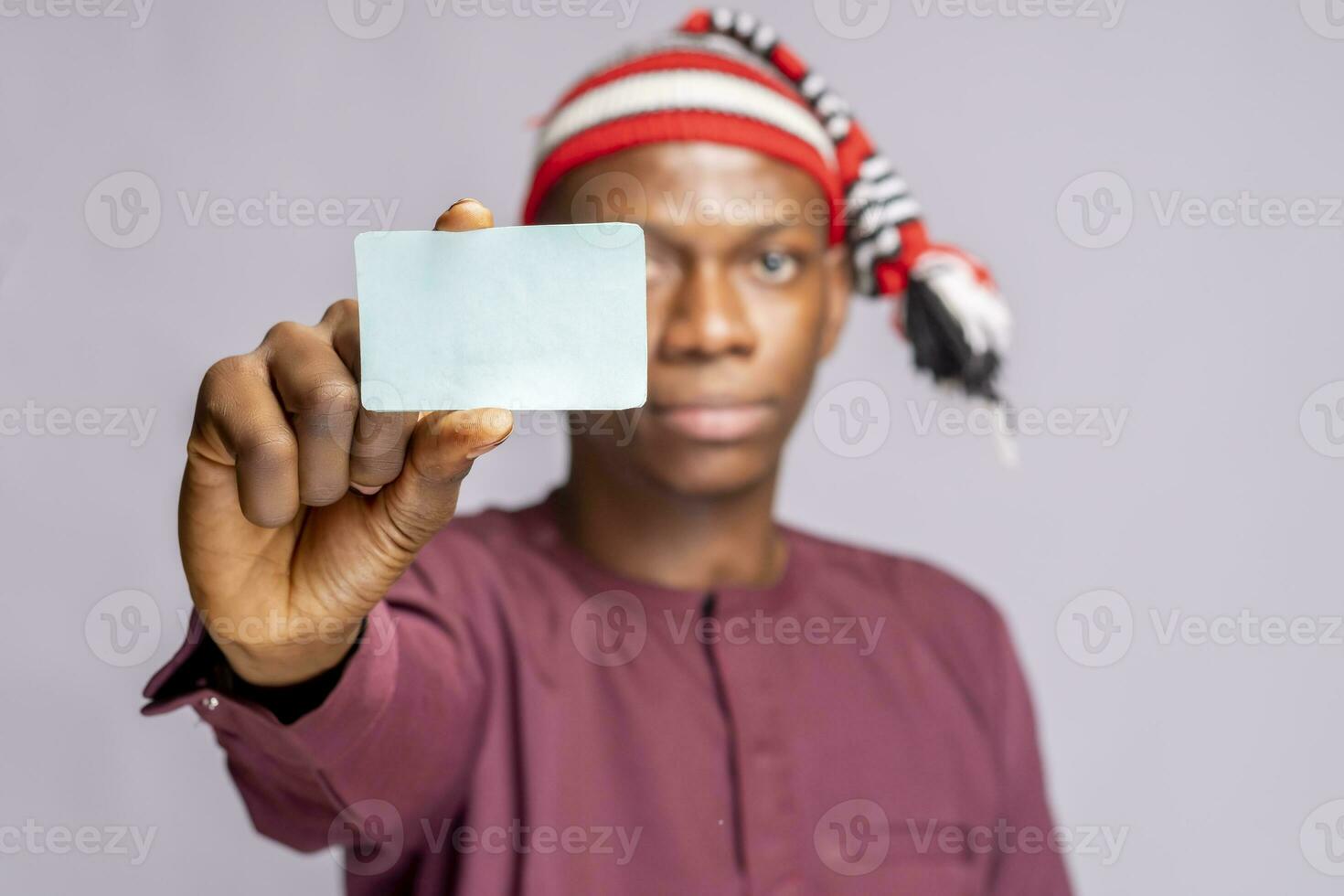 africano hombre vistiendo africano atuendo vestir participación carné de identidad tarjeta burlarse de arriba . selectivo atención foto