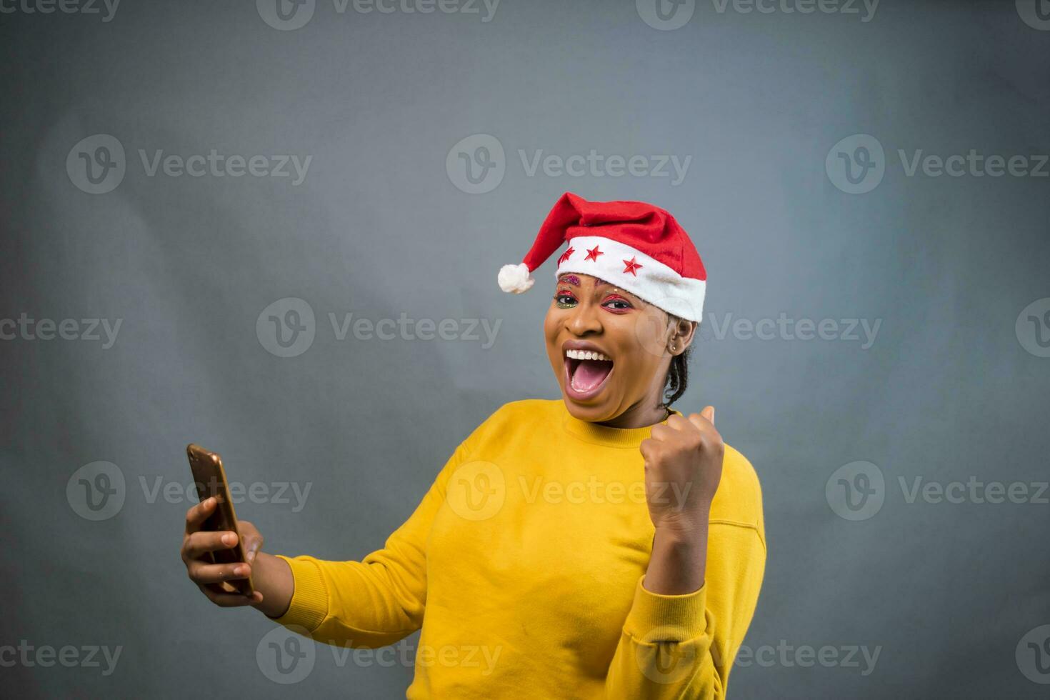 excited lady on Christmas  hat feeling excited about what she saw on her phone photo