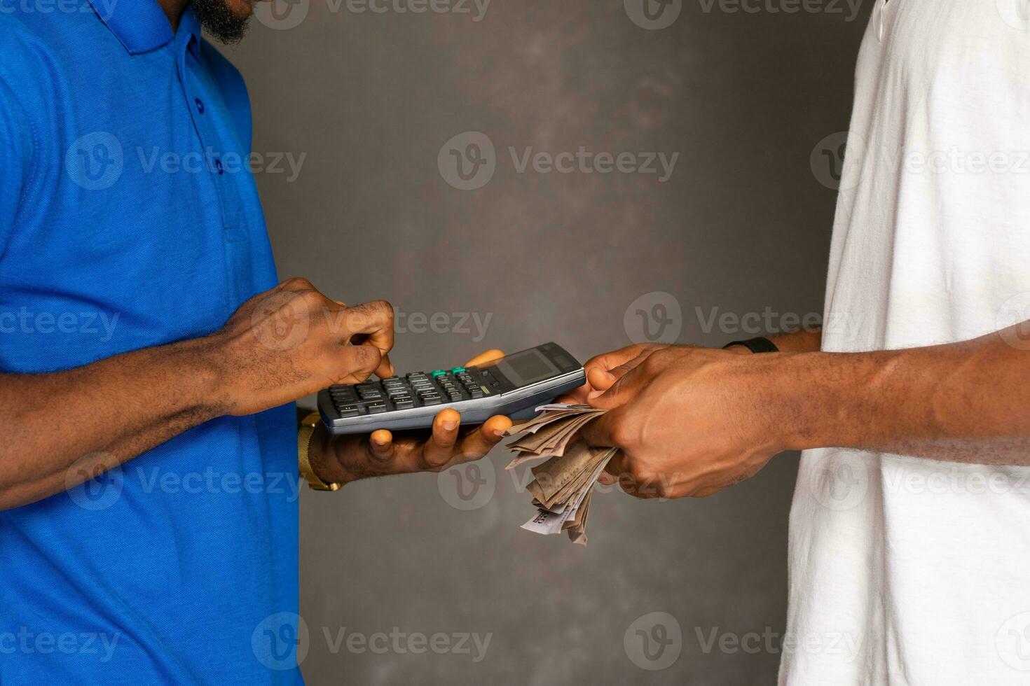 a trader using a calculator and a customer counting money to make payment photo