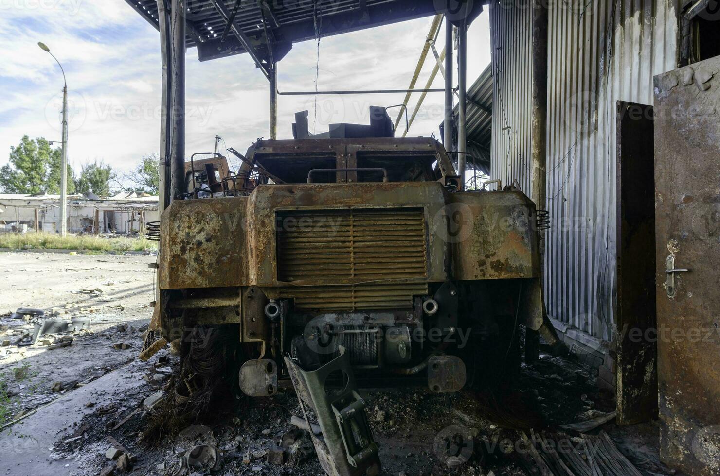 burnt military armored car on the street of the ruined city photo