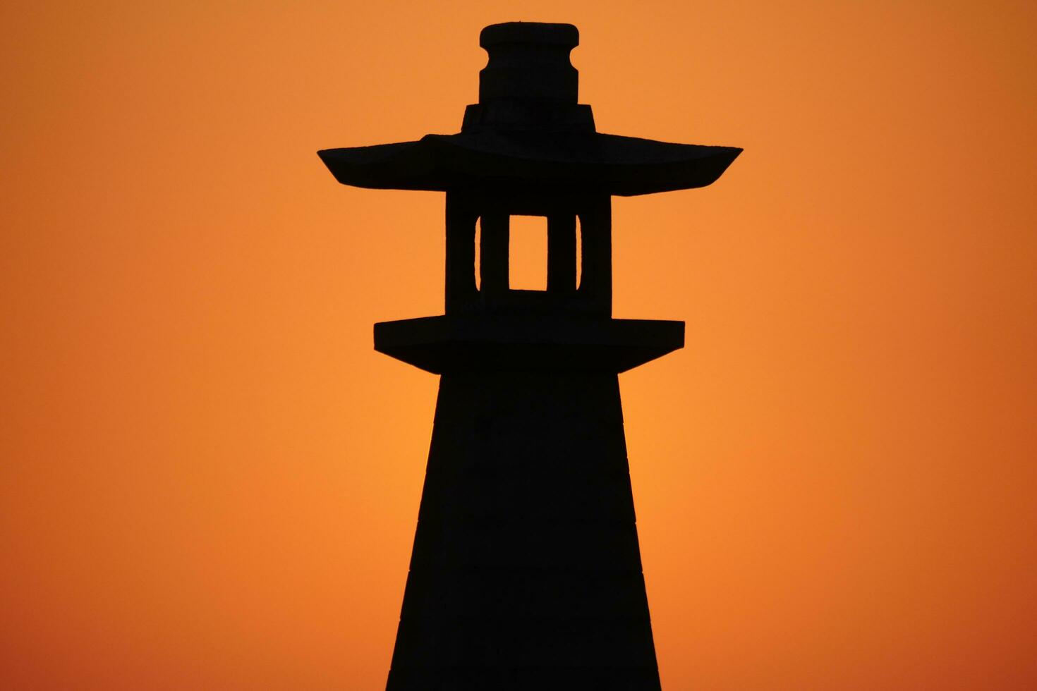 traditional Japanese lighthouse at sunset photo