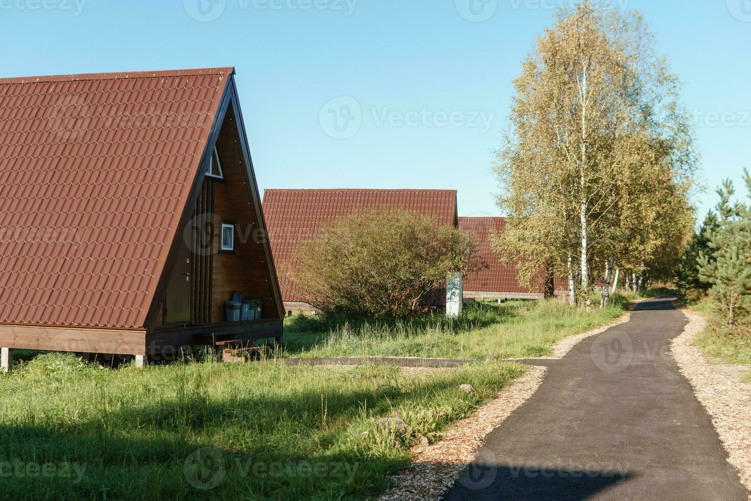 The concept of glamping and renting a chalet for weekend. Wooden house with a veranda in nature around coniferous trees photo