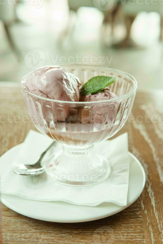 Closeup of cherry granita in glass bowl, on color wooden background photo