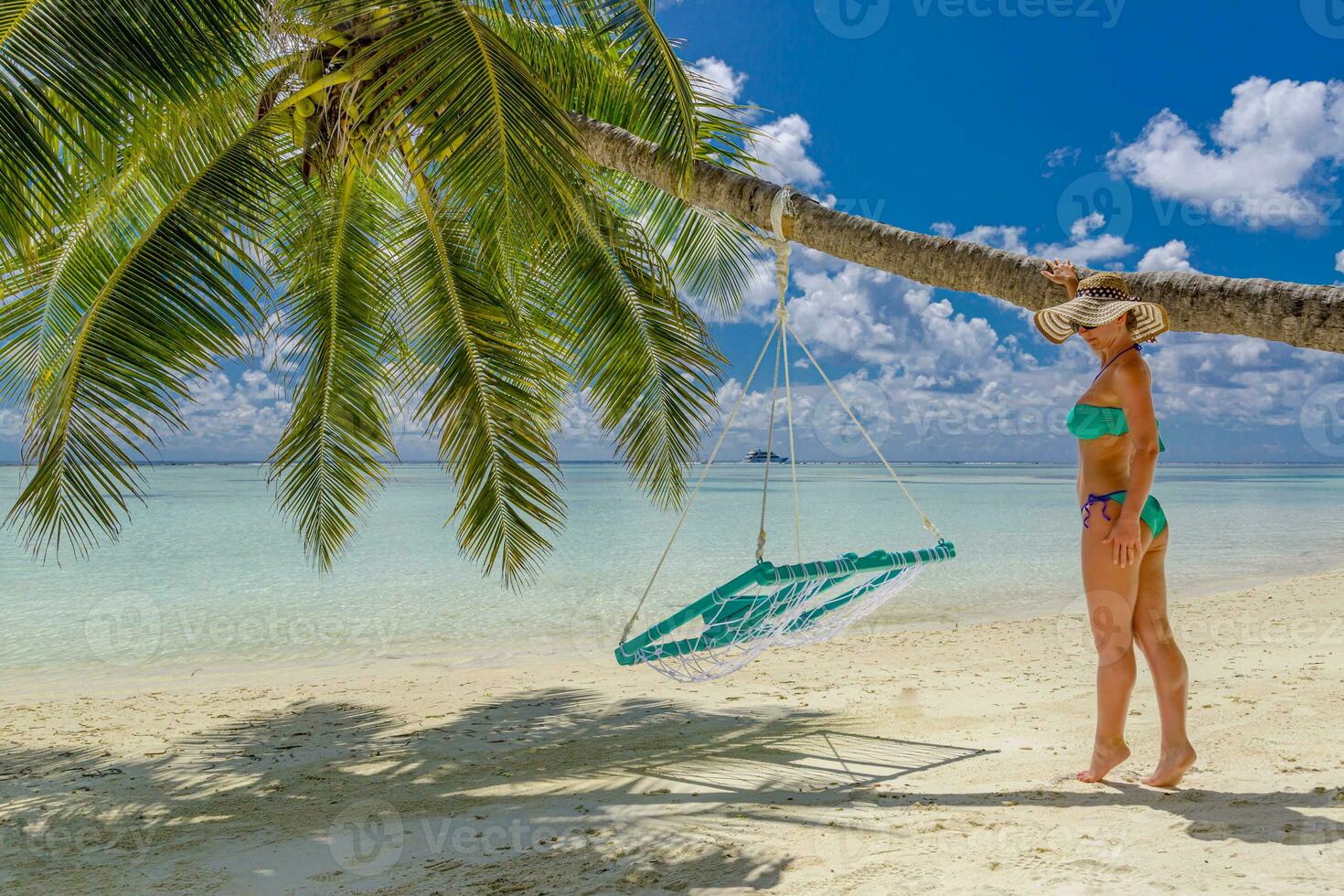 Idyllic tropical beach landscape with young sexy woman posing on the beach backwards for background or wallpaper. Design of tourism for summer vacation holiday destination concept. photo