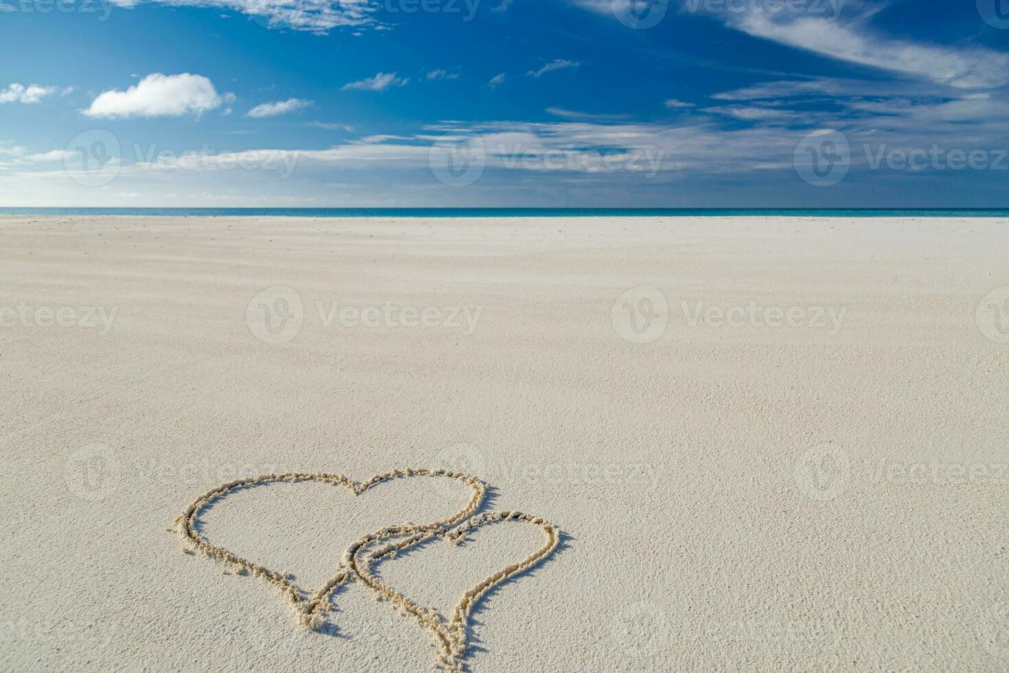 Two heart symbol sand of beach background design. Romantic love concept photo