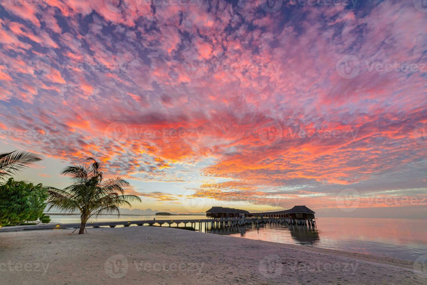 Amazing beach landscape. Beautiful Maldives sunset seascape view. Horizon colorful sea sky clouds, over water villa pier pathway. Tranquil island lagoon, tourism travel background. Exotic vacation photo