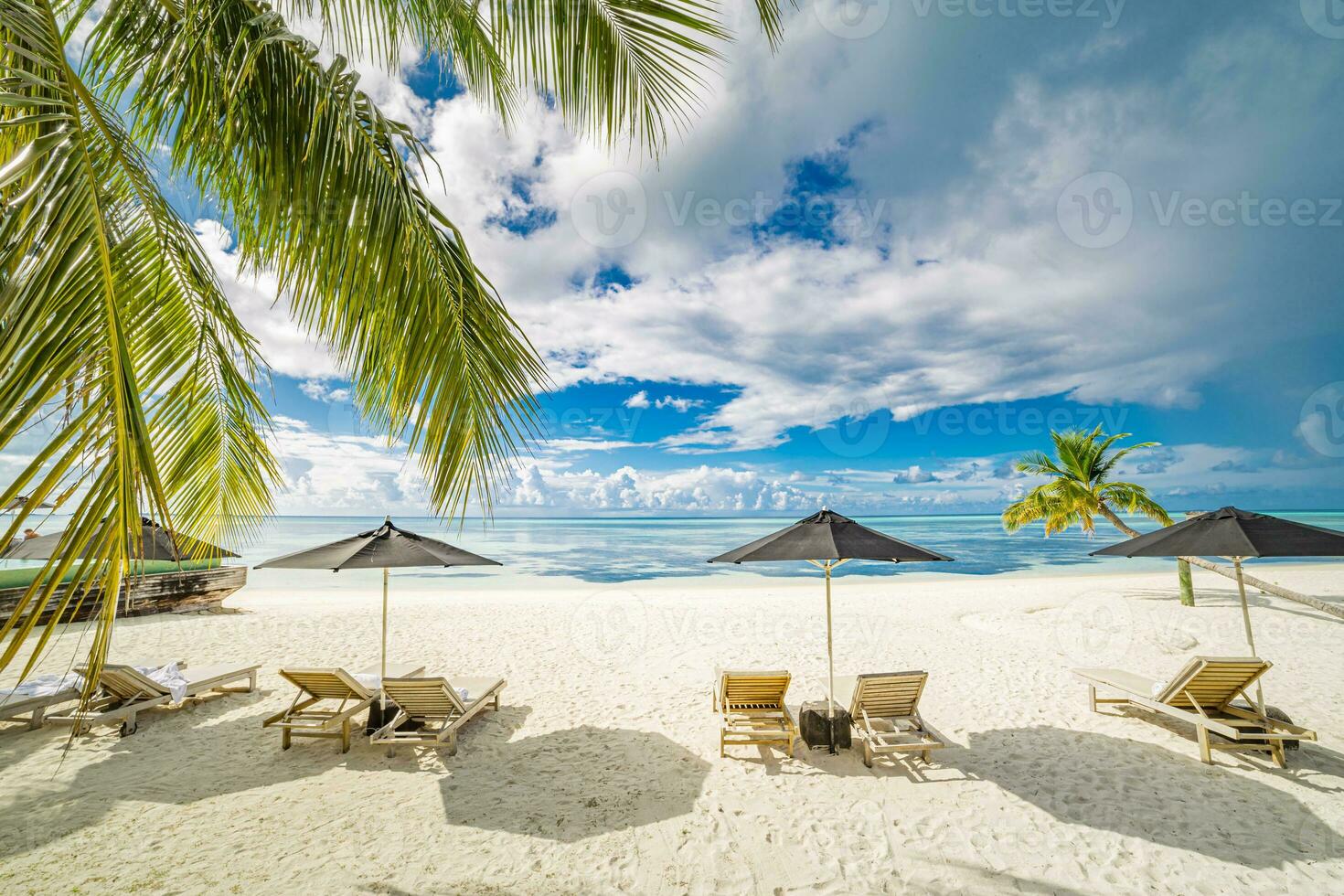 Beautiful tropical island scenery, two sun beds, loungers, umbrella under palm tree. White sand, sea view with horizon, idyllic blue sky, calmness and relaxation. Inspirational beach resort hotel photo