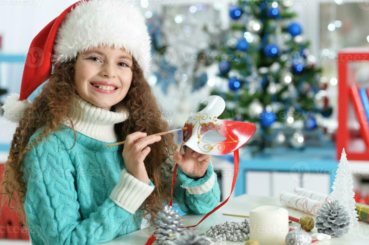 Happy girl in Santa hat sitting with Christmas present photo