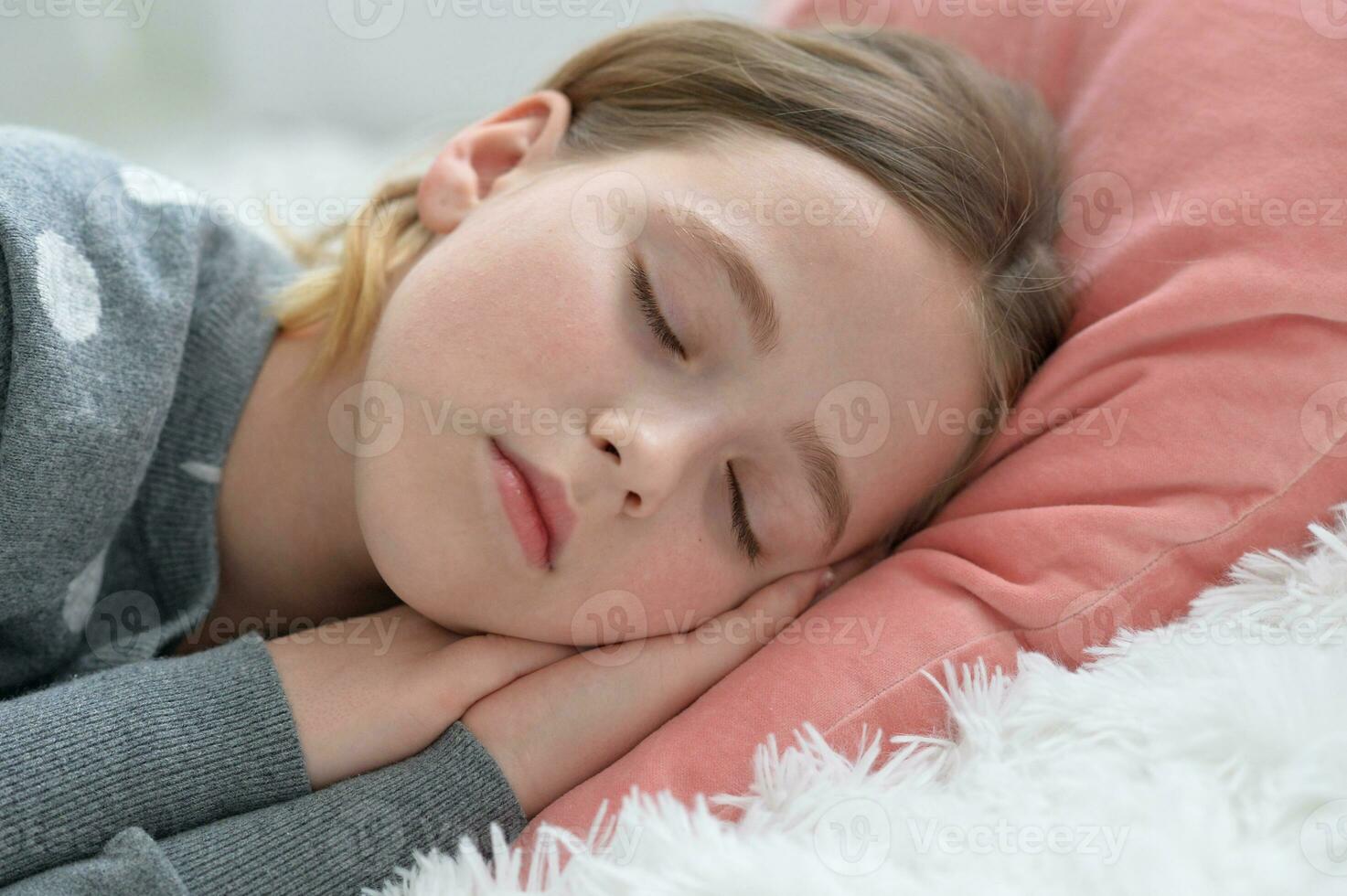 Sweet little girl sleeping in a bed photo