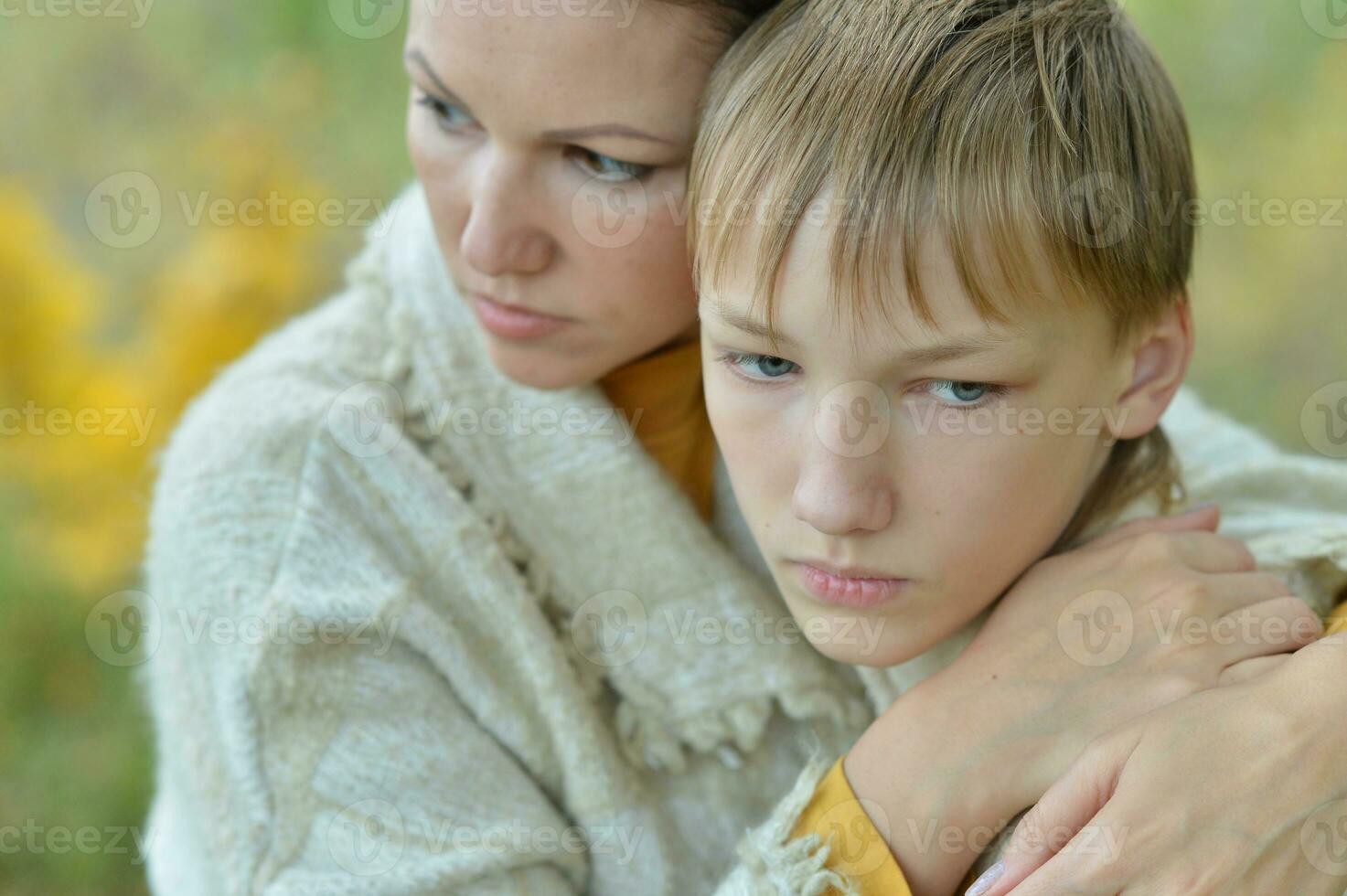 Sad mother with son on a walk in park photo