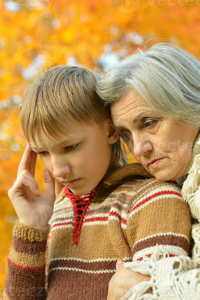 Sad Grandmother with boy in the park photo