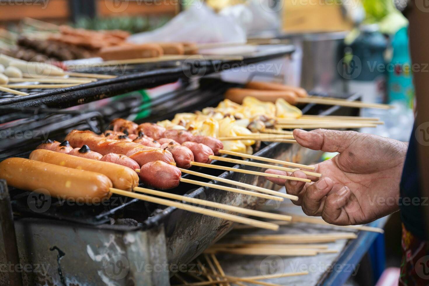 tailandés calle alimento, delicioso A la parrilla salchicha y albóndigas y calamar madera brochetas menú, A la parrilla en carbón parrilla. de venta a lo largo el la carretera lado en Bangkok ciudad. foto