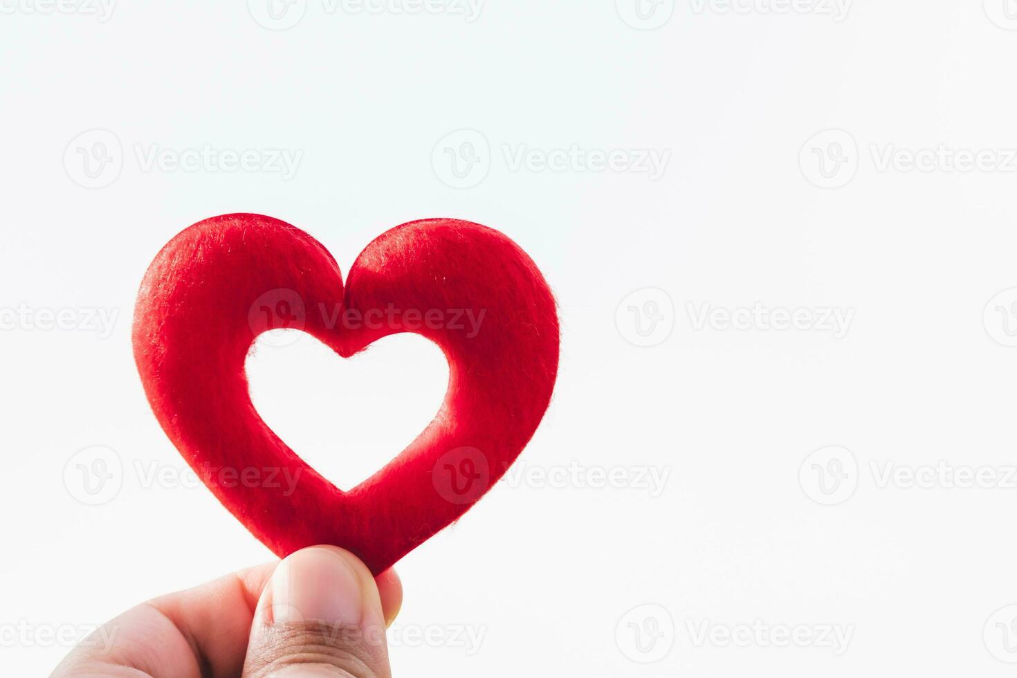 Hand holding red heart on white background isolated. Valentine's Day concept. Empty space for entering text. photo