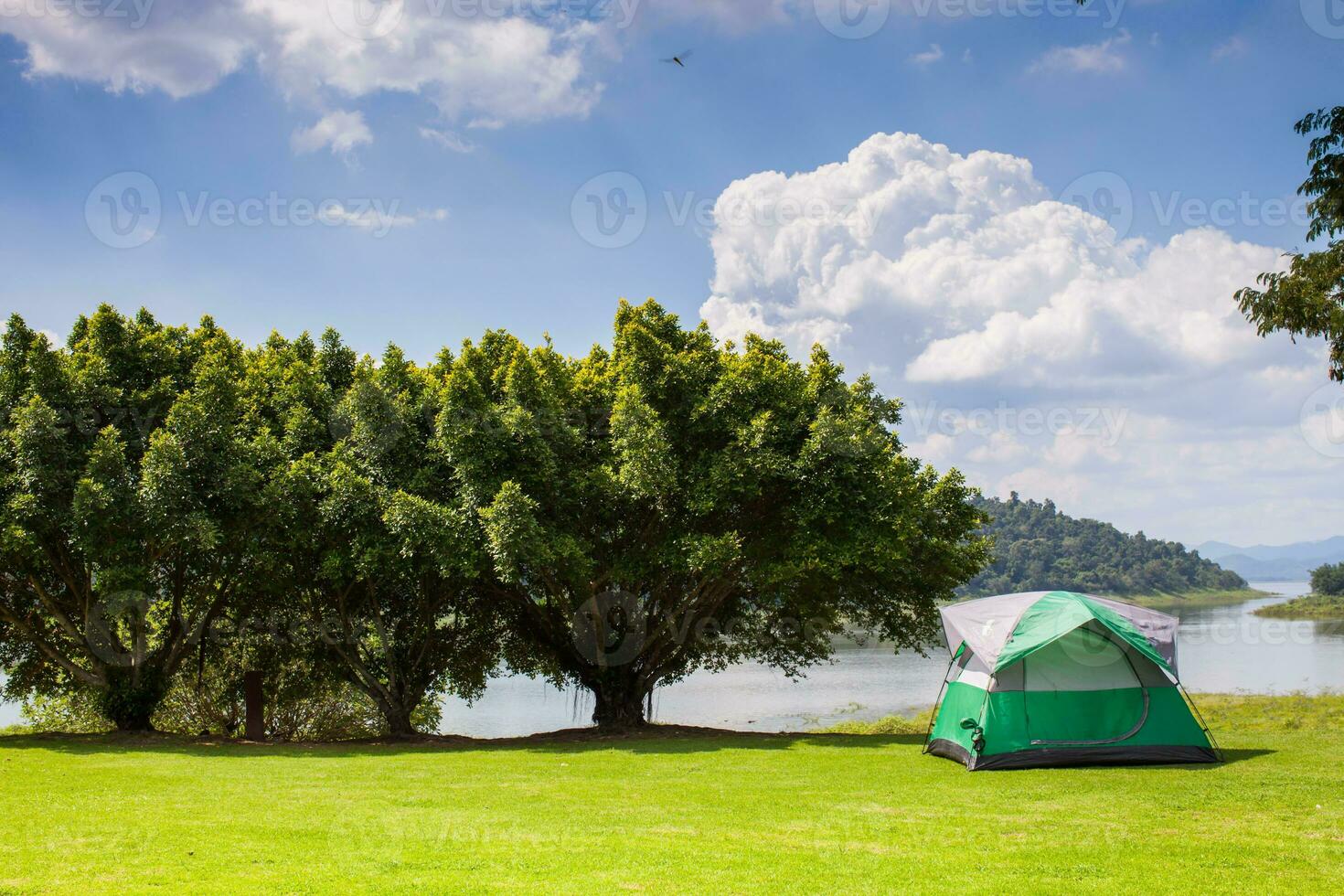 Camping tent on green grass field under clear sky photo