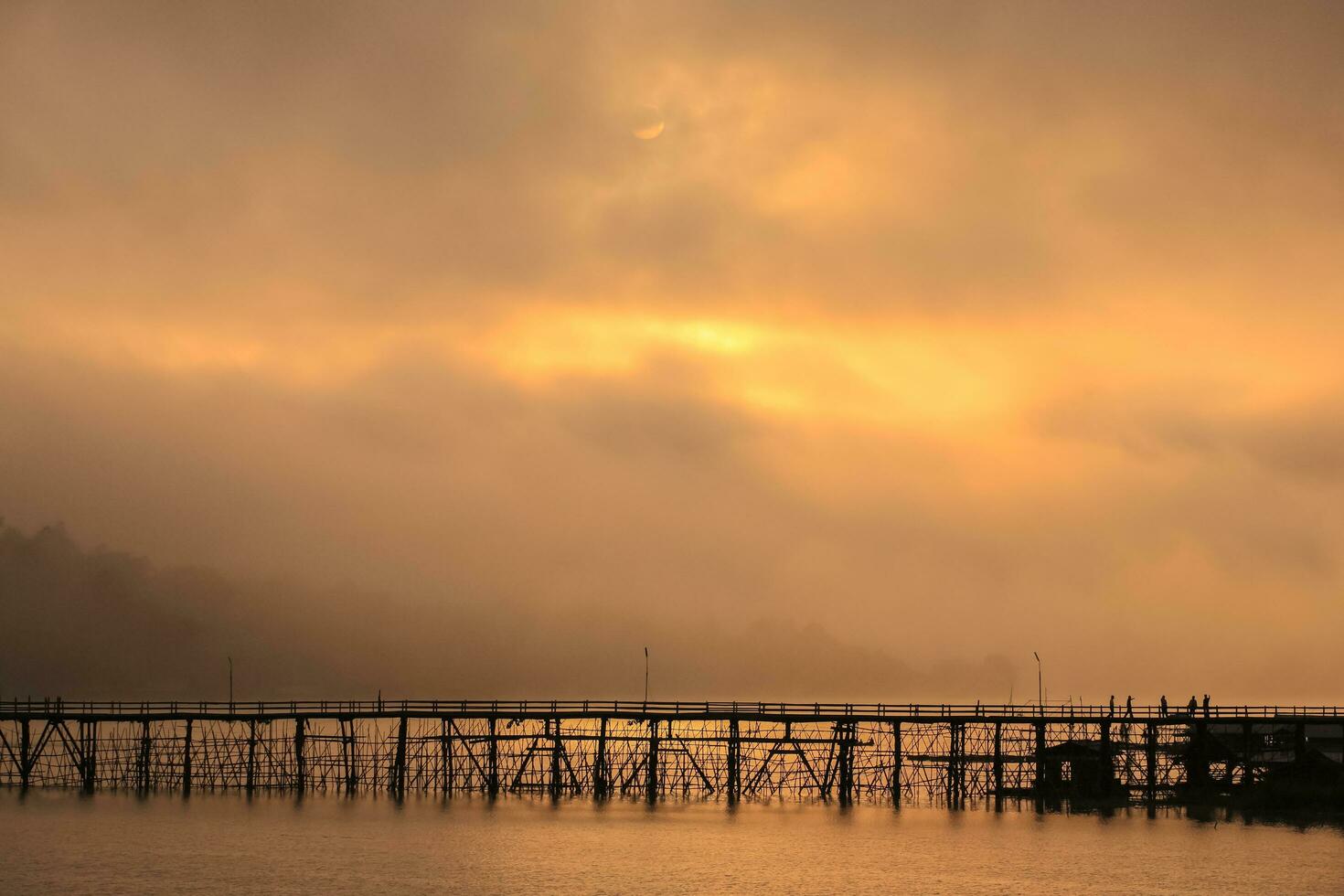 bridge across river at sunrise reflection on water photo