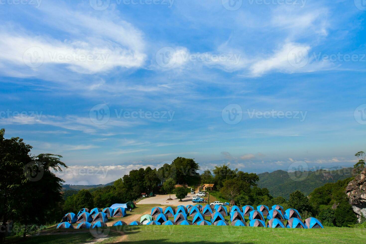 Camping tent on green grass againts sky photo