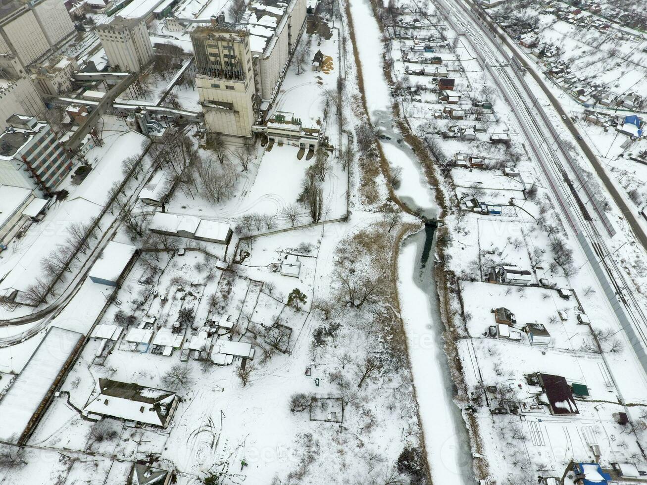 rociado con nieve grano ascensor. invierno ver de el antiguo Soviético ascensor. invierno ver desde el aves ojo ver de el aldea. el calles son cubierto con nieve foto