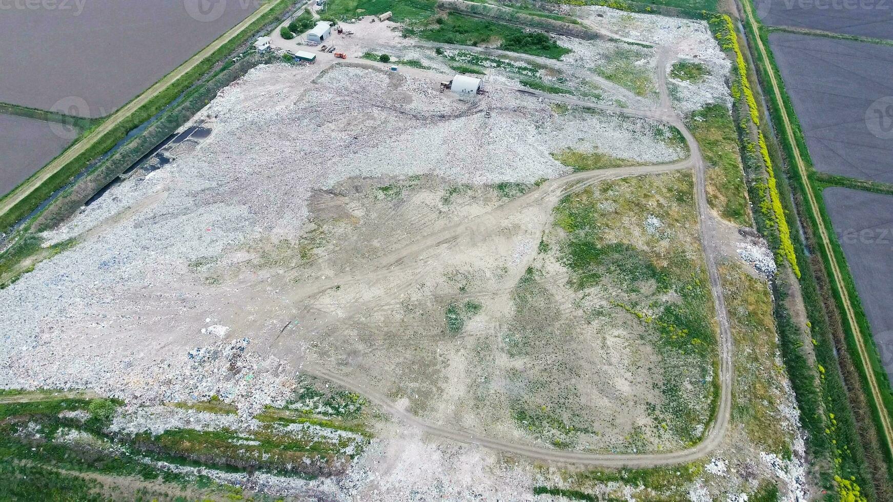 garbage dump with heaps of garbage and treatment facilities. Landfill of garbage outside the village photo