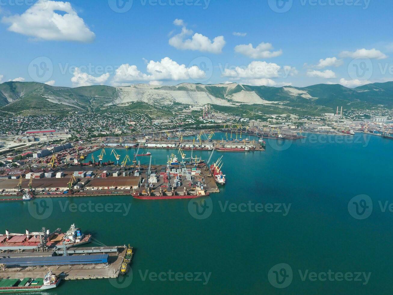 Industrial seaport, top view. Port cranes and cargo ships and barges. Loading and shipment of cargo at the port. View of the sea cargo port with a bird's eye view photo