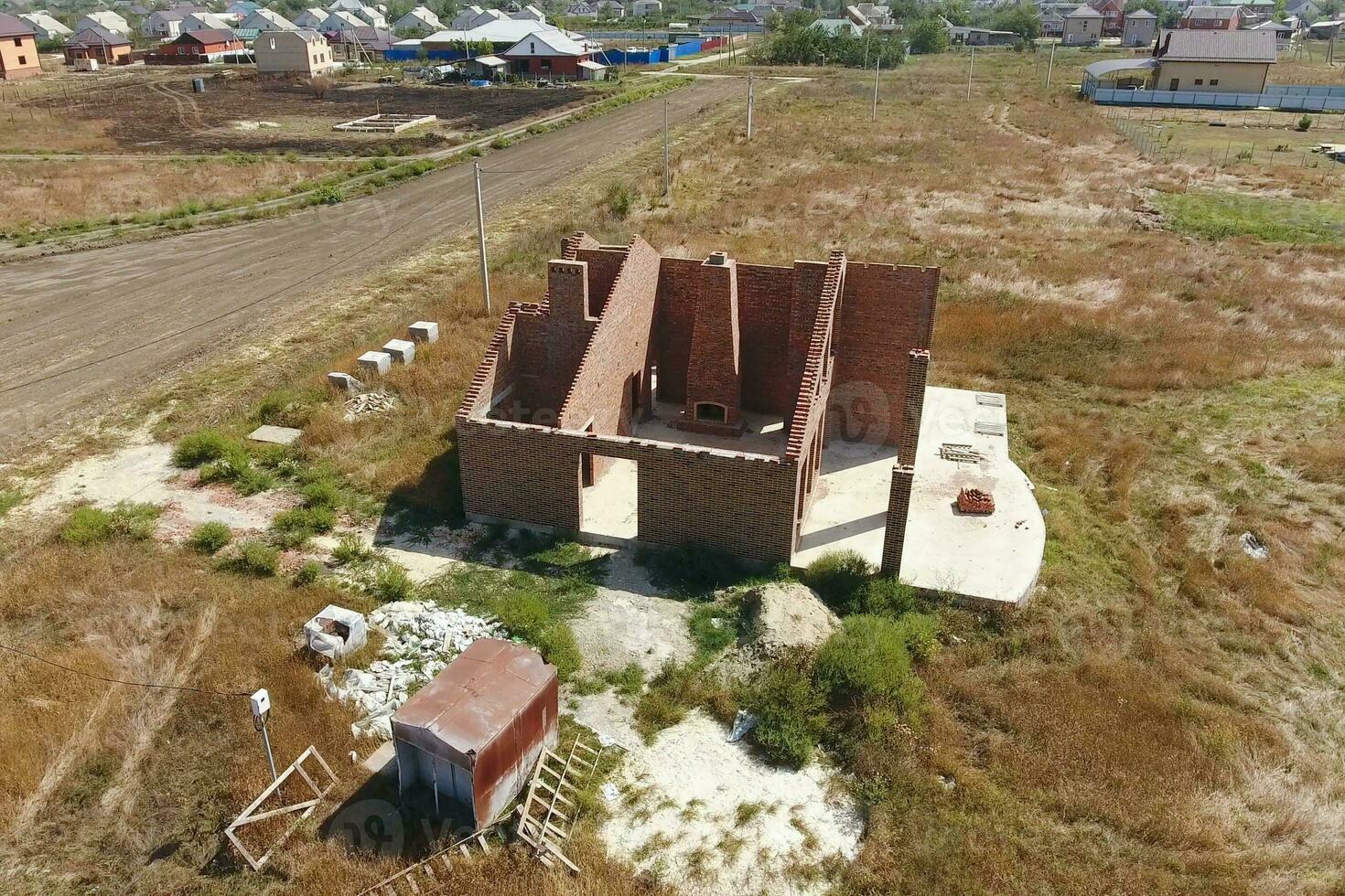 el casa es construido de rojo ladrillo. el paredes de el casa son un parte superior ver foto