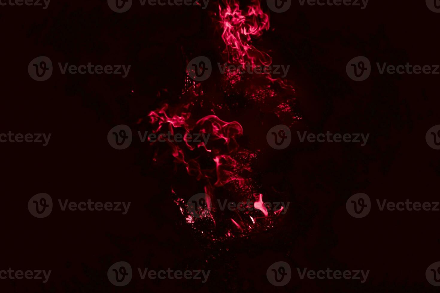 A dark red flame. Burning of rice straw at night. photo