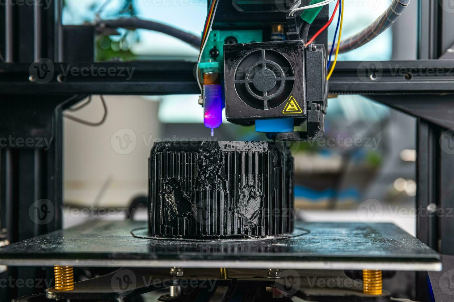 A 3D printer prints a black model. Technology at home photo