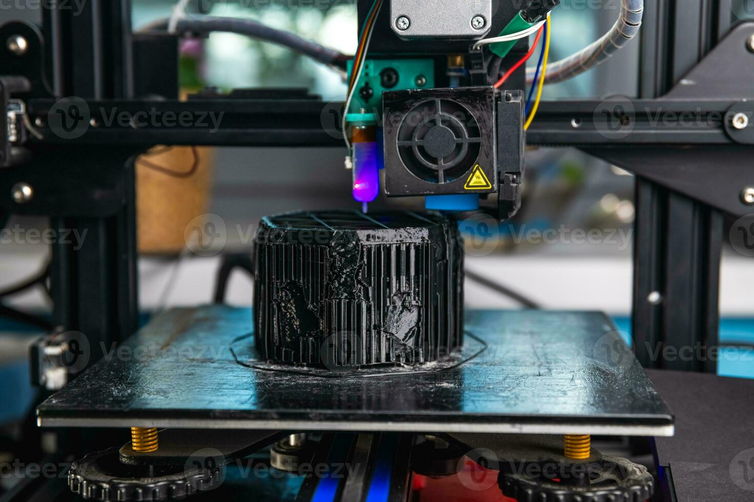 A 3D printer prints a black model. Technology at home photo