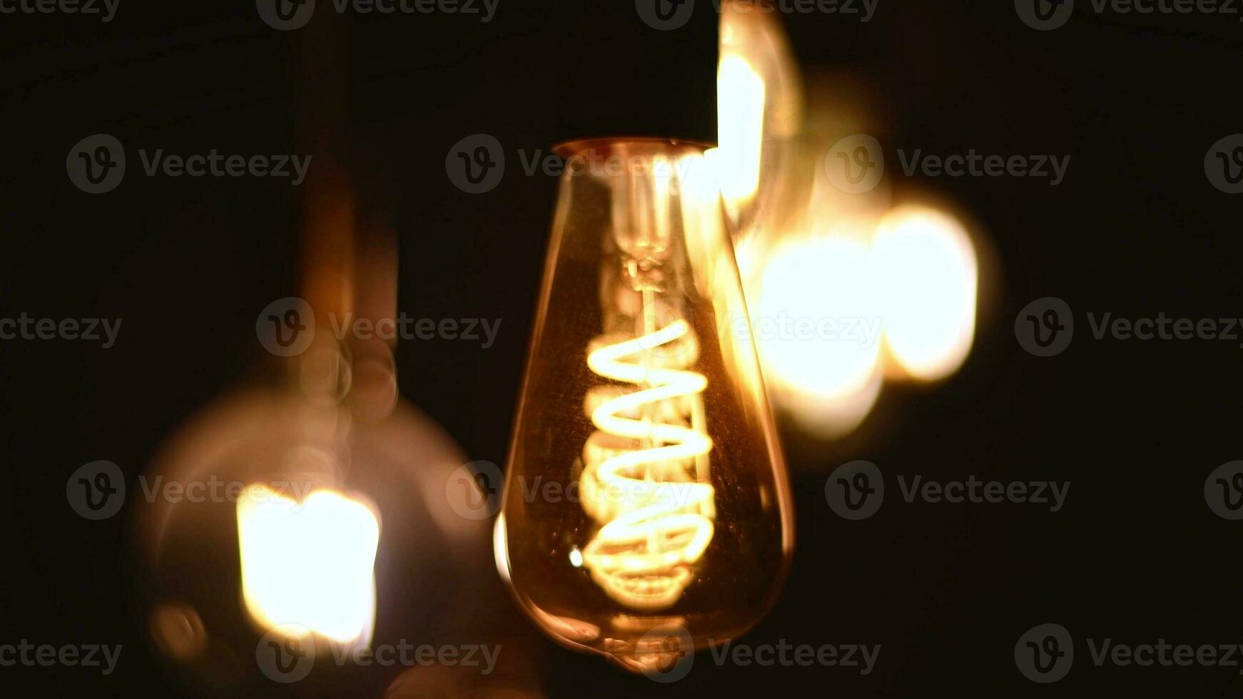 Spiral Retro light bulbs hanging on a dark background. Electricity, Vintage photo