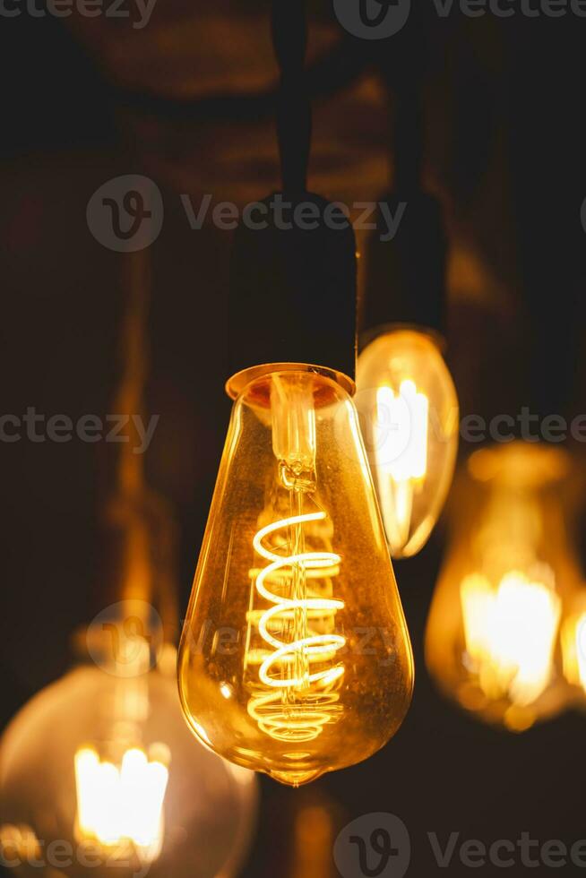 Spiral Retro light bulbs hanging on a dark background. Electricity, Vintage photo