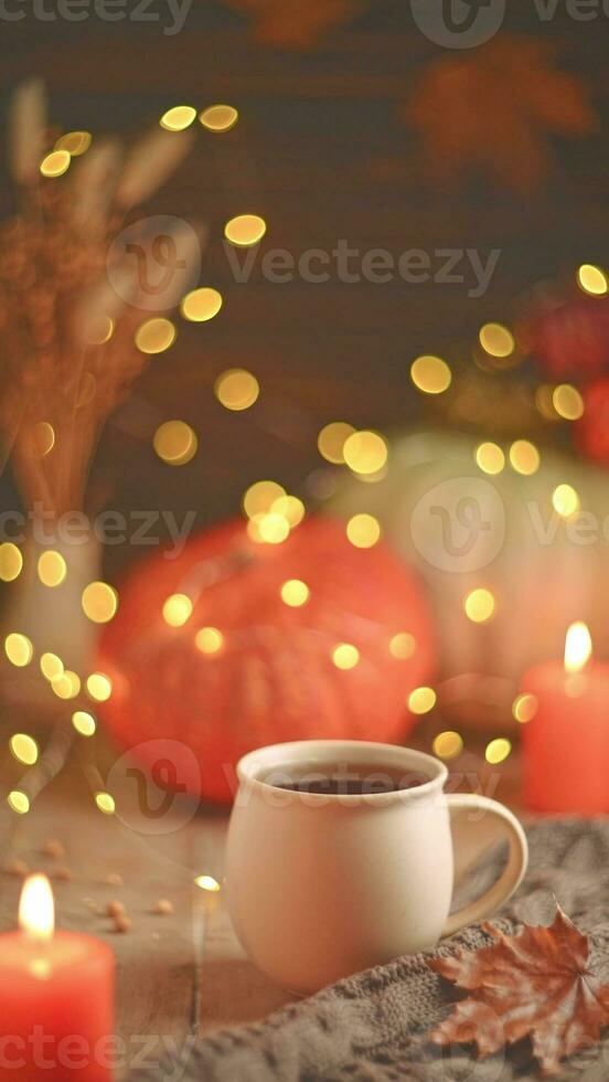 Autumn cozy composition. Tea in a mug, pumpkins and candles photo