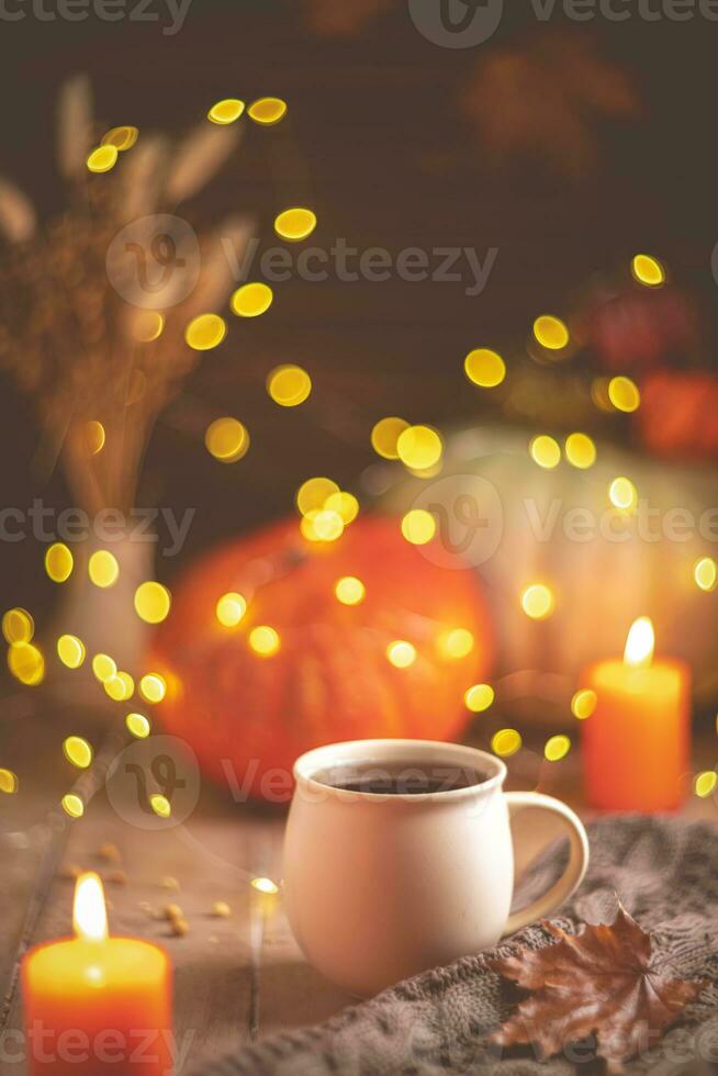 Autumn cozy composition. Tea in a mug, pumpkins and candles photo