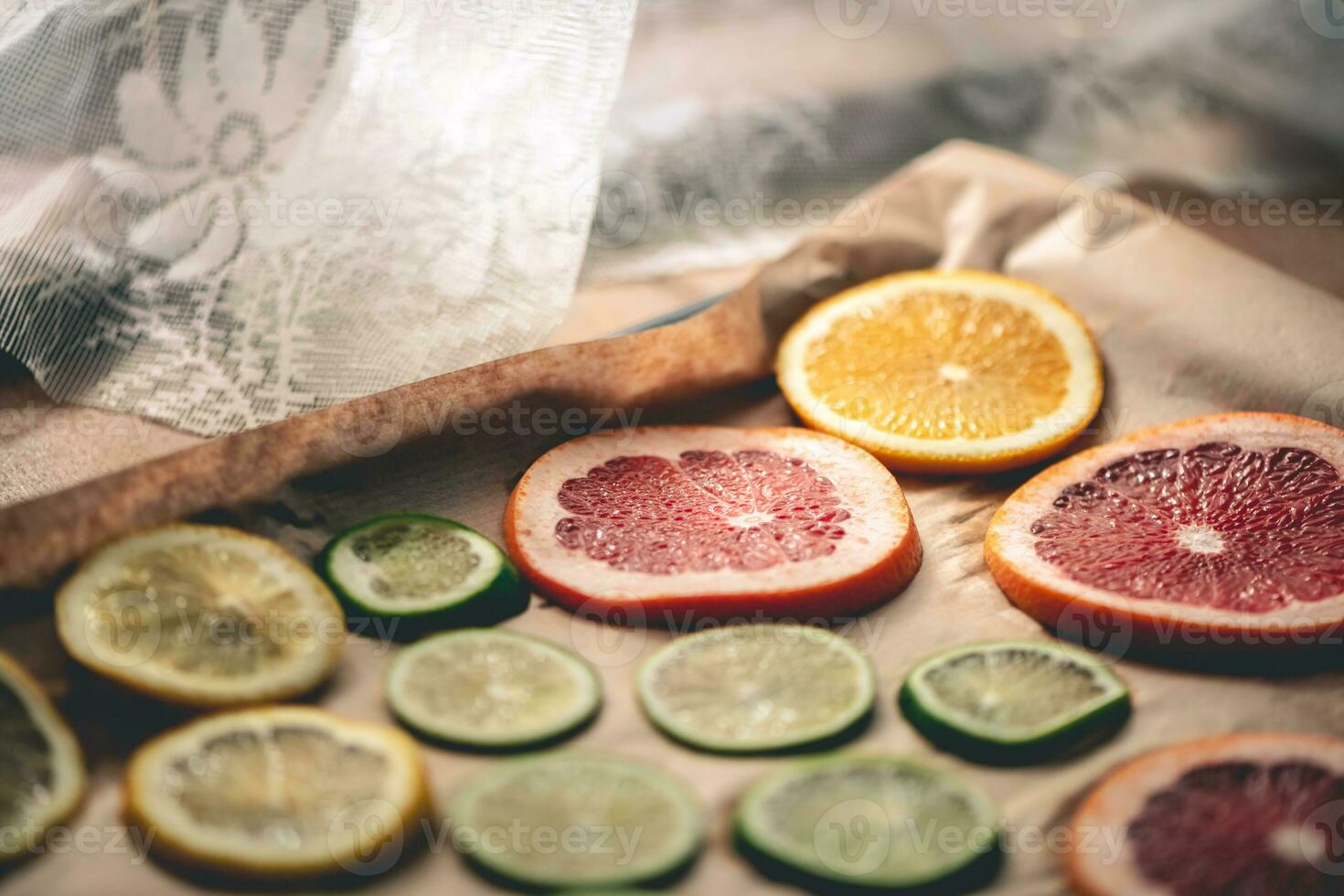 Sliced orange, tangerine and grapefruit slices on baking sheet, preparing citrus wedges for Christmas garland photo