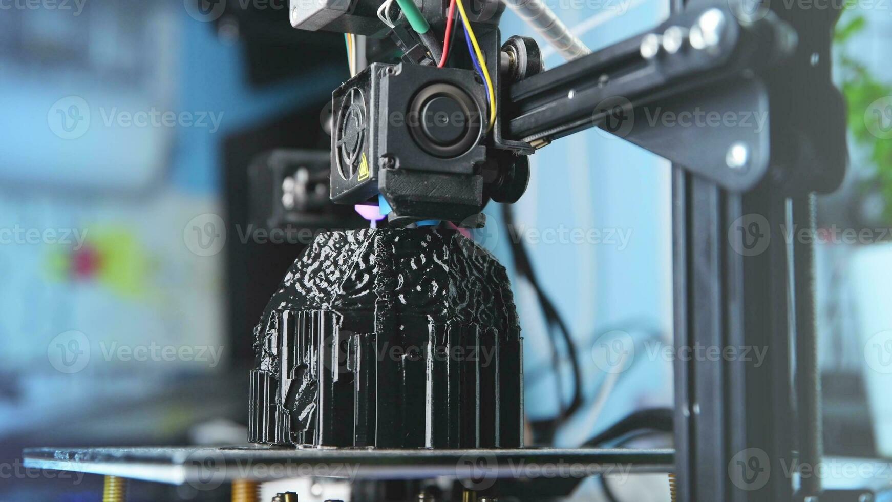 A 3D printer prints a black model. Technology at home photo