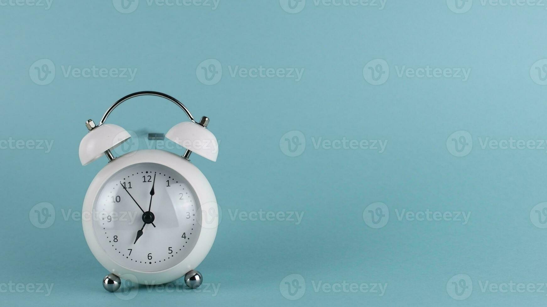 White alarm clock ringing, on blue background photo