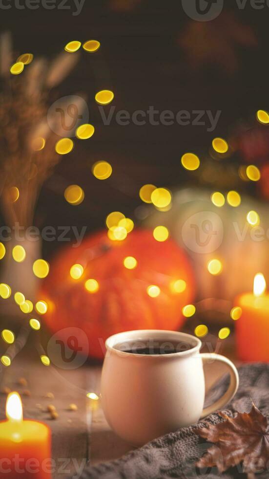 Autumn cozy composition. Tea in a mug, pumpkins and candles photo