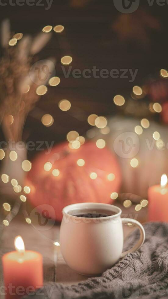 Autumn cozy composition. Tea in a mug, pumpkins and candles photo