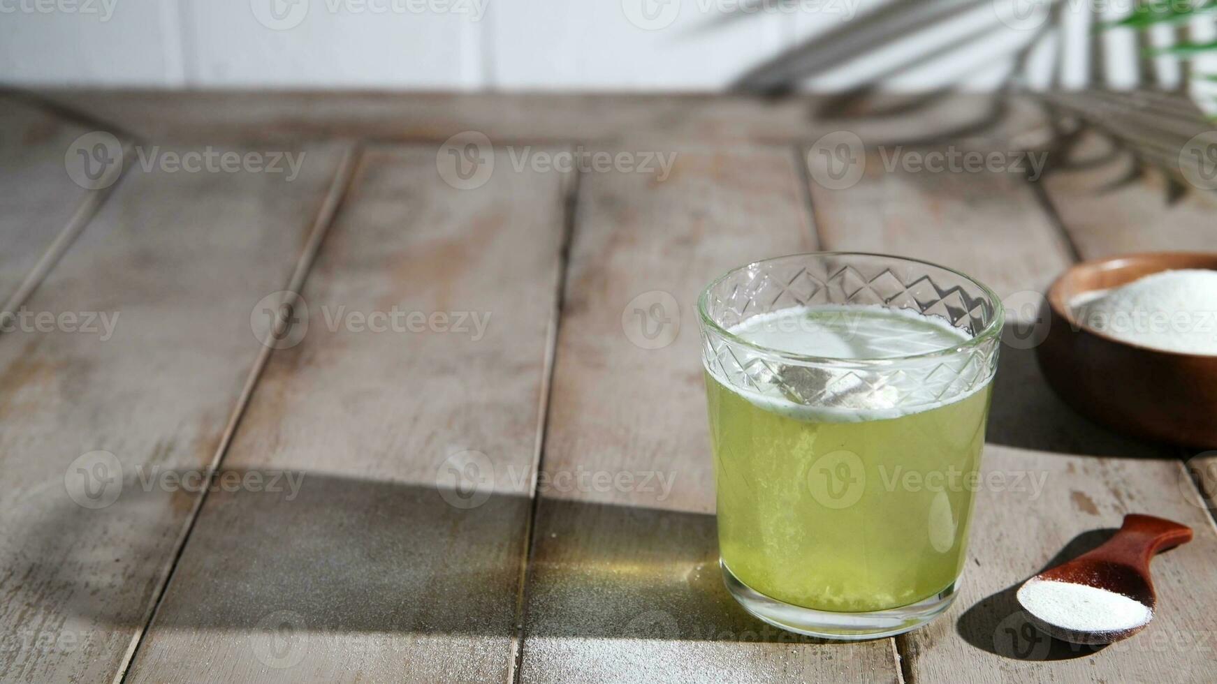 matcha Collagen powder in glass of water. photo