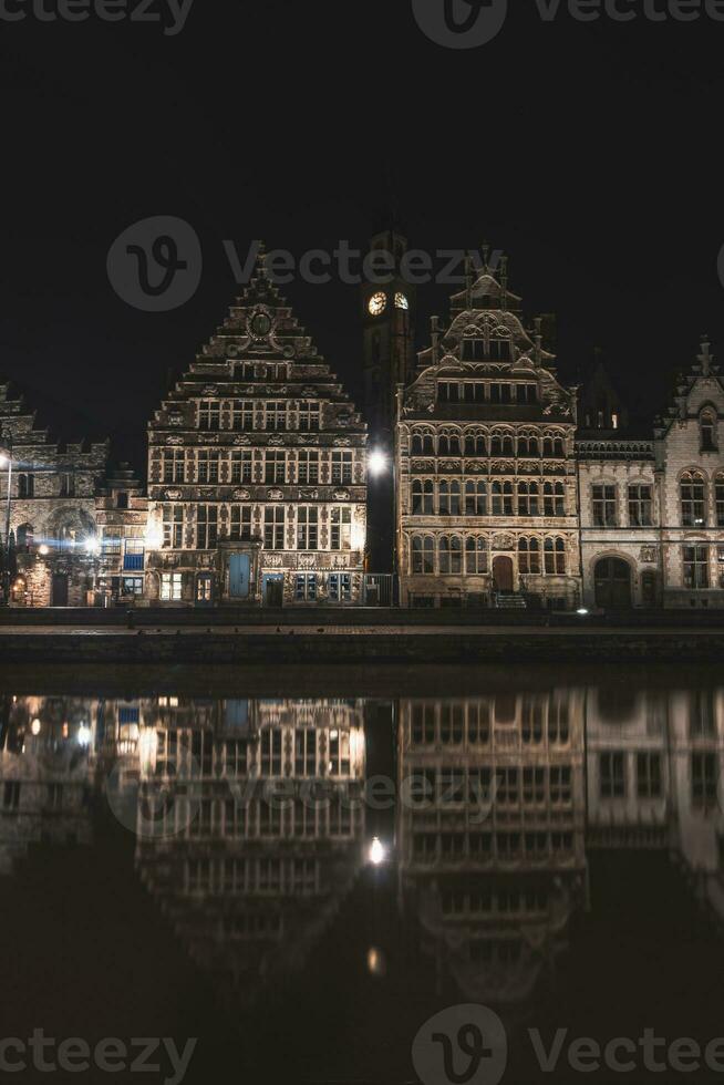 medieval edificios en graslei calle en el centrar de Gante por el río ley durante el noche. Bélgica más famoso histórico centro. Gante frente al mar durante medianoche foto