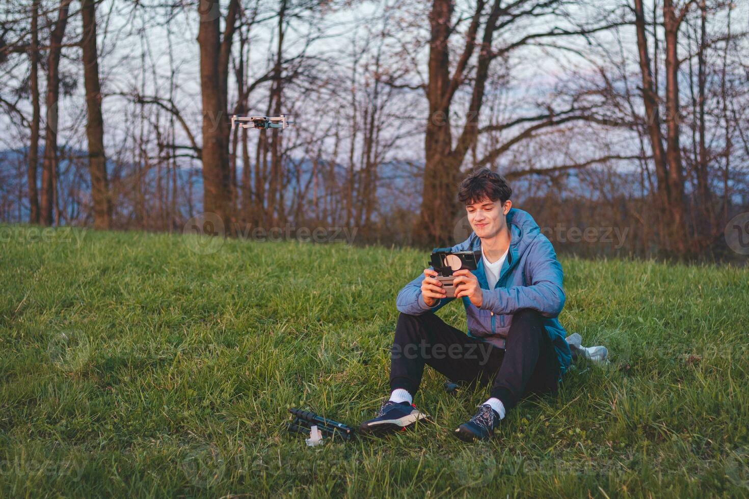 Young cinematographer shoots parts of a film using a technological product called a drone. Recording the sunset from an aerial view photo